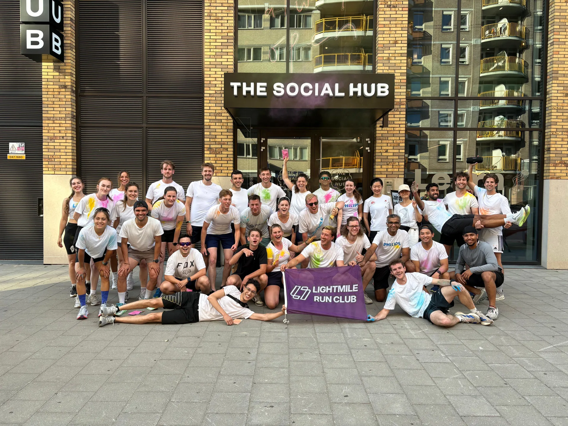 The full Lightmile crew gathered with the club flag in front of The Social Hub