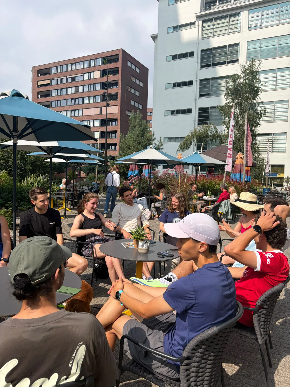 Lightmile runners sitting around terrace tables in Eindhoven, talking after a run